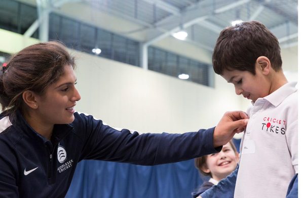 Naomi Dattani presenting a Middlesex badge to a Cricket Tikes player